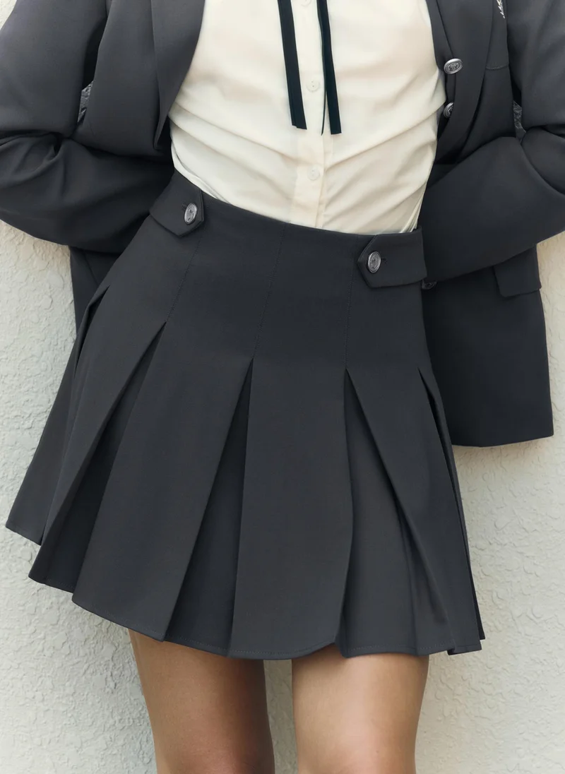 ليتشي تنورة مطوية قصيرة مع أزرار معدنية على حزام الخصر